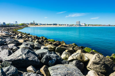 Scenic view of rocky coastline by sea against sky