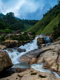 Scenic view of waterfall against sky