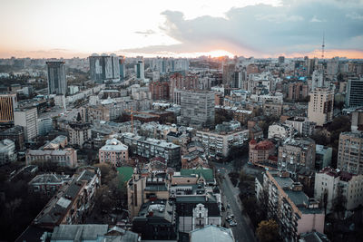 High angle view of modern buildings in city against sky during sunset