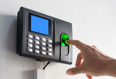 Close-up of hand holding camera against wall