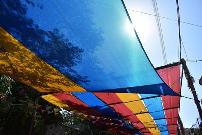 Low angle view of multi colored umbrellas on sunny day