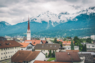 Aerial view of townscape and mountains against sky