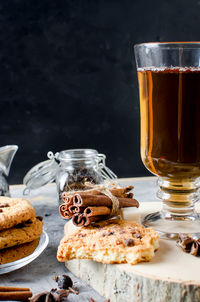 Close-up of tea cup by cookies on cutting board over table