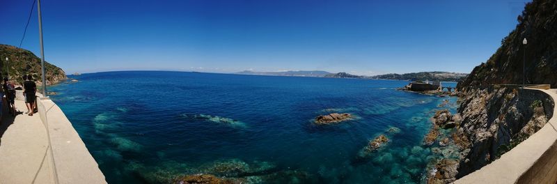 Panoramic view of bay against clear blue sky