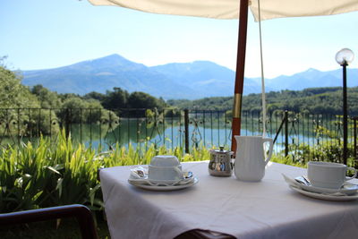 Coffee on table by mountains against sky