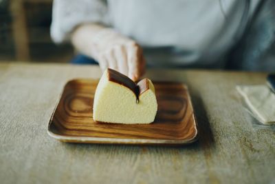 Close-up of hand holding bread on table