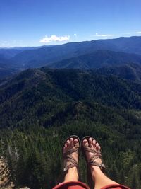 Low section of person on mountain against sky