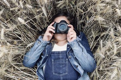 Portrait of man photographing camera on field