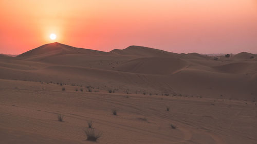 Scenic view of desert against sky during sunset