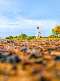 Man standing on field against sky