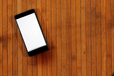 High angle view of smart phone on wooden table