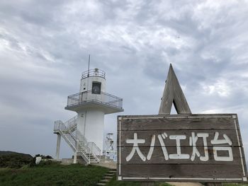 Low angle view of sign on building against sky