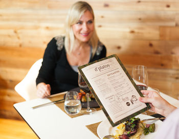 Cropped image of man holding menu in restaurant