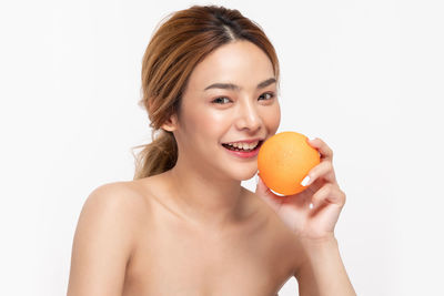 Portrait of a smiling young woman against white background
