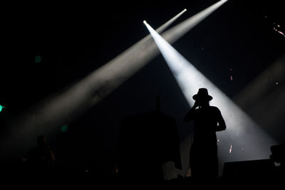 Silhouette man standing in illuminated stage at night