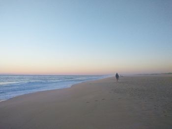 View of calm beach against clear sky