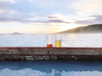 Drinks kept on poolside against sea 
