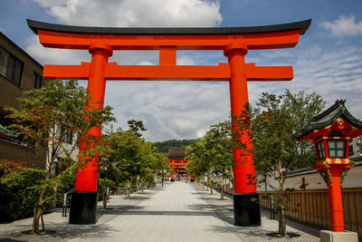 Red temple amidst buildings against sky