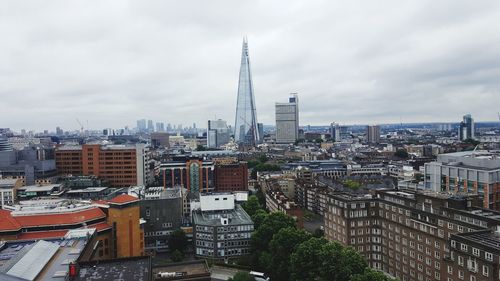 View of cityscape against cloudy sky