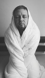 Close-up of man sitting against wall