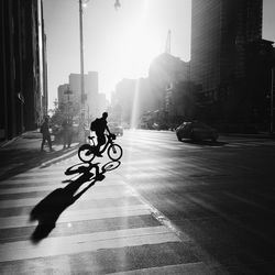 Silhouette of man with bicycle in city