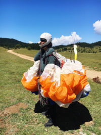 Man holding parachute while standing on land