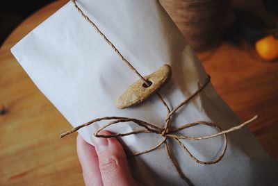 Cropped hand holding package at table