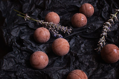 Chocolate round candies on dark crumpled craft paper with lavender flowers