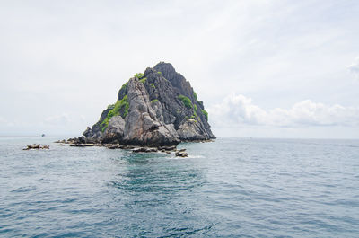 Rock formation in sea against sky