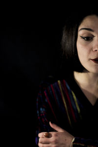 Beautiful young woman over black background