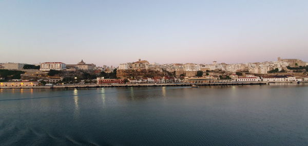 City by river against clear sky