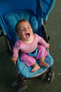 High angle view of baby screaming in stroller on field