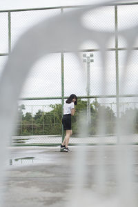 Side view of woman looking through window