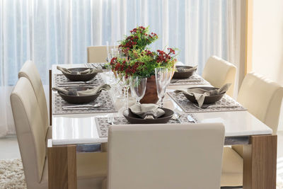 Empty chairs arranged around dining table