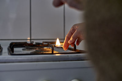 Close-up of hand lighting up gas stove burner