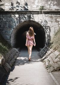 Full length of boy walking in tunnel