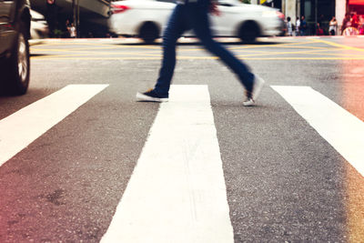 Low section of man walking on city street