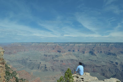 Rear view of woman standing on landscape against sky