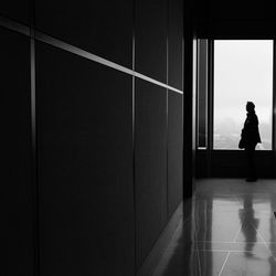 Silhouette man standing by window in building