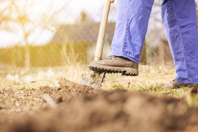 Low section of man standing on field