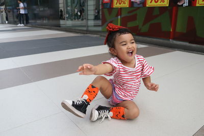 Full length of cute girl sitting on floor