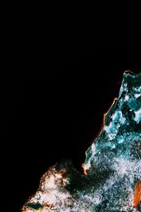 Snow covered mountain against black background