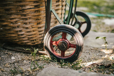 Close-up of wicker basket by wheel on ground