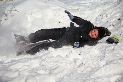 High angle view of boy falling in snow