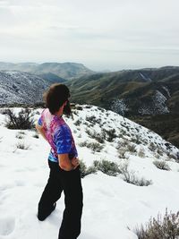 Woman standing on snow covered landscape