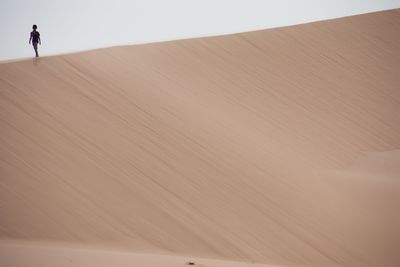 Boy standing at sandy desert
