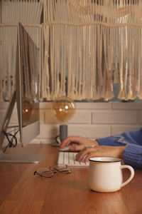 The woman works from home at the computer. workplace at a wooden table in a cozy home