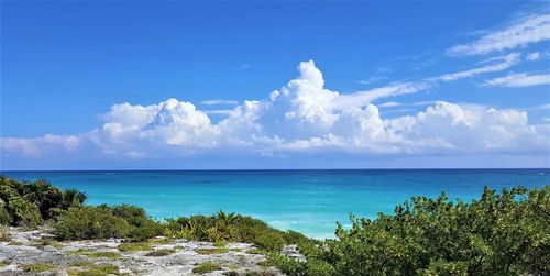 Scenic view of blue sea against blue sky with majestic clouds 