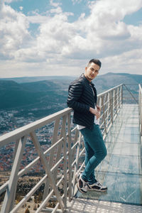 Full length of man on railing against sky