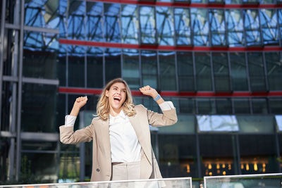 Portrait of young woman standing in city